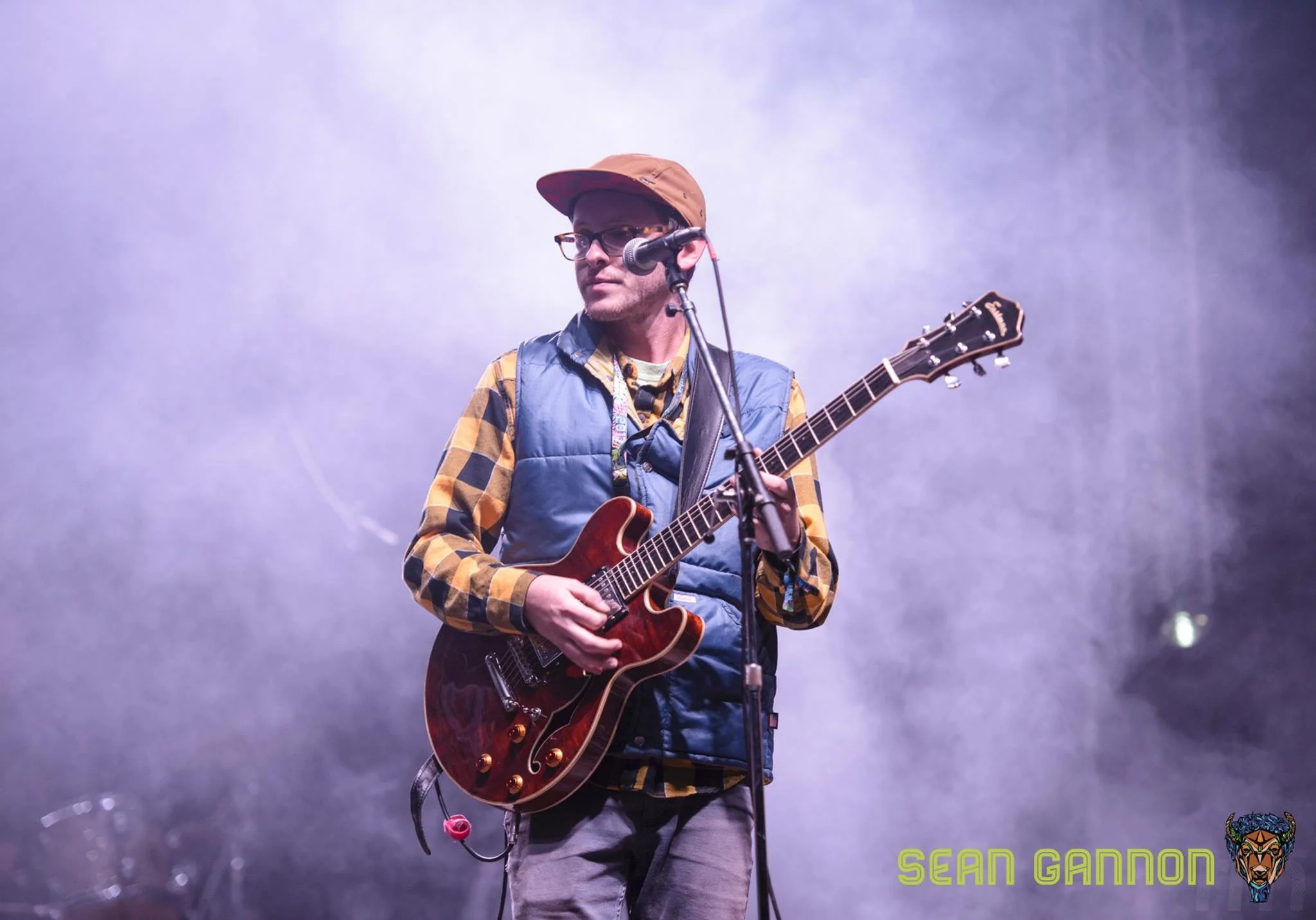 Jordan Smith singing into a microphone and playing electric guitar on stage. Photo by Sean Gannon.